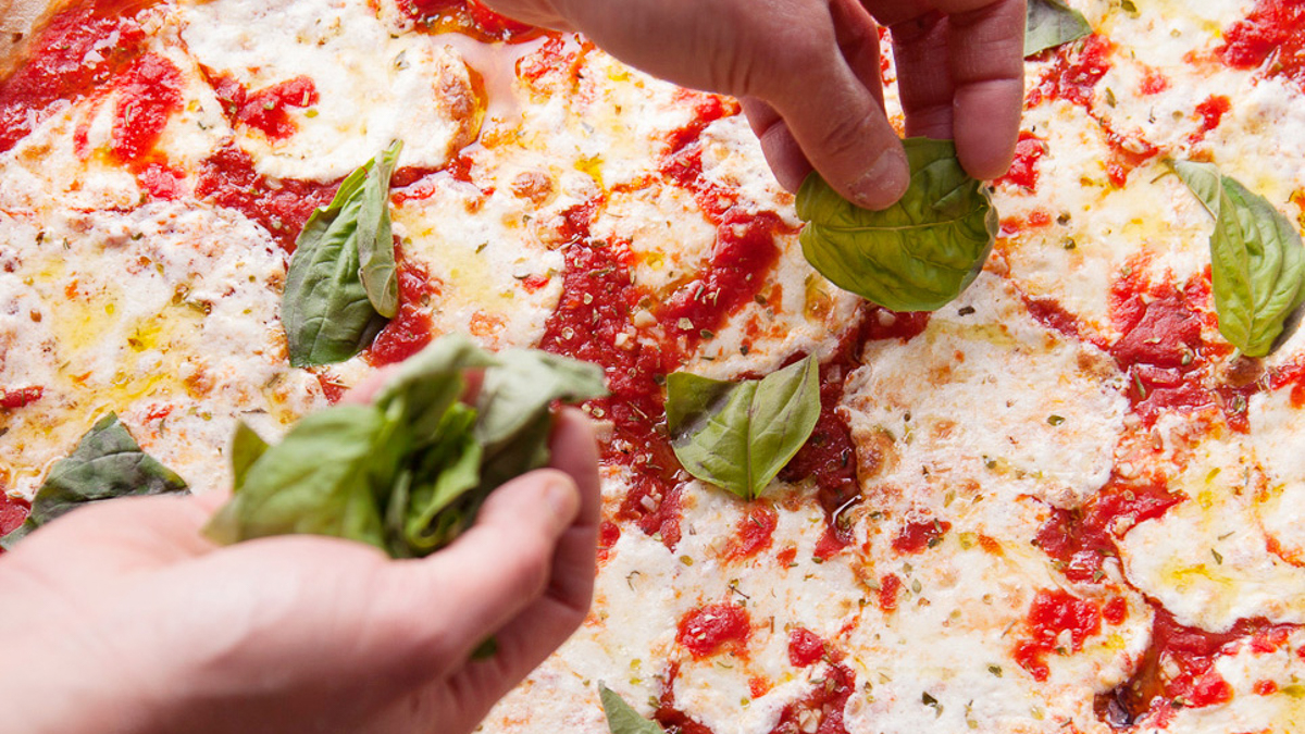 Tomato sauce, olive oil, mozzarella, garlic, basil, and oregano on the Hello Rita pizza at Hello Pizza.